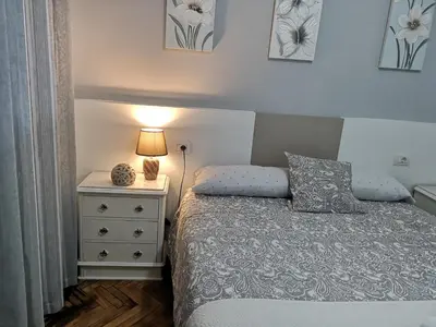 a bedroom with a bed and a nightstand with a lamp at Ático Camino De Santiago 2 in Sarria