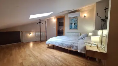 a bedroom with a bed and a desk with a light at Dúplex Plaza Saco y Arce in Ourense