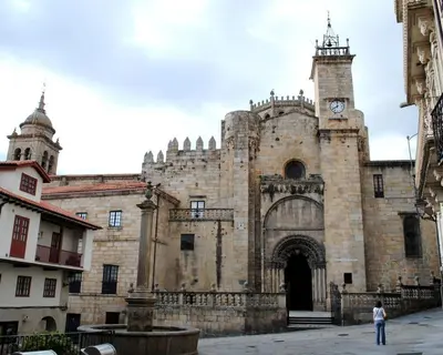 a large stone building with a clock tower on it at Dúplex Plaza Saco y Arce in Ourense