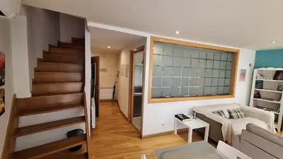 a living room with a staircase and a couch at Dúplex Plaza Saco y Arce in Ourense