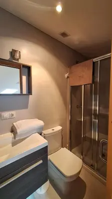 a bathroom with a toilet and a glass shower at Dúplex Plaza Saco y Arce in Ourense