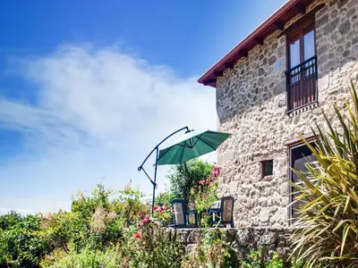 a green umbrella sitting on the side of a building at Farmhouse in Castrotañe with Terrace in Castillón