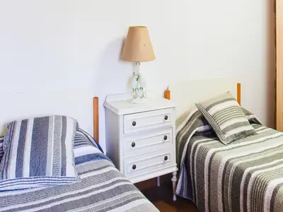 a bedroom with two beds and a night stand with a lamp at Farmhouse in Castrotañe with Terrace in Castillón