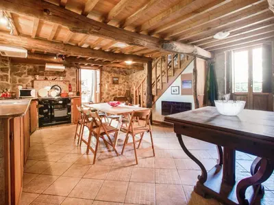 a kitchen with a table and chairs in a room at Farmhouse in Castrotañe with Terrace in Castillón