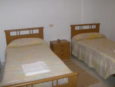 a bedroom with two beds and a dresser with towels at Pensión Monterredondo in Meira
