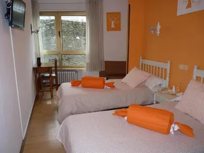 a room with two beds with orange towels on them at Hotel España in Lugo