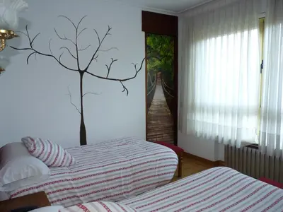 a bedroom with a bed and a tree on the wall at Hotel España in Lugo