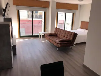 a living room with a couch and a bed at Apartamentos Augusto in La Cañiza