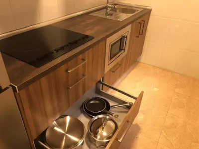 a kitchen with a stove with pots and pans on it at Apartamentos Augusto in La Cañiza