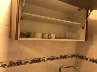 a bathroom with a cupboard with dishes on it at Apartamentos Augusto in La Cañiza