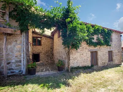 a stone building with trees in front of it at Traditional Apartment in Ribeira Sacra with Garden in Castillón