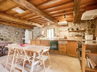 a kitchen with a wooden table and chairs at Traditional Apartment in Ribeira Sacra with Garden in Castillón