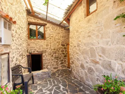 a stone building with a bench and a window at Traditional Apartment in Ribeira Sacra with Garden in Castillón