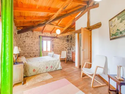 a bedroom with a bed and a table and chairs at Traditional Apartment in Ribeira Sacra with Garden in Castillón