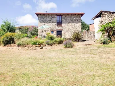 an old stone house with a garden in front of it at Traditional Apartment in Ribeira Sacra with Garden in Castillón