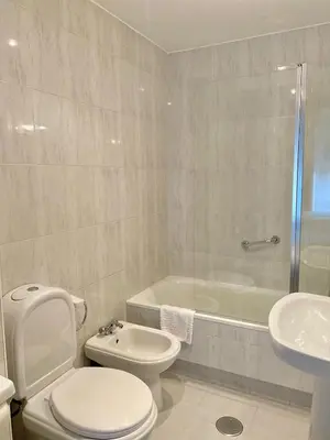 a bathroom with a toilet and a sink and a tub at Pensión Residencia Fornos in Santiago de Compostela