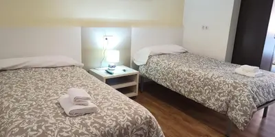 a bed with towels and balls of yarn on it at Pensión La Estación in Sarria