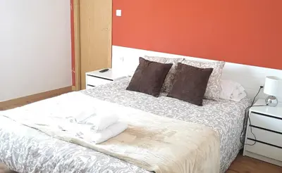 a bedroom with a bed with towels on it at Pensión La Estación in Sarria