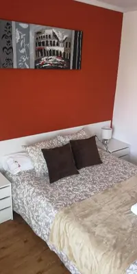 a bedroom with a bed with two pillows at Pensión La Estación in Sarria