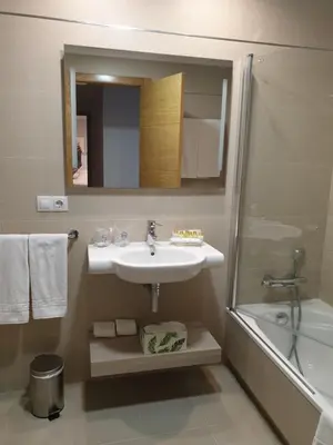 a bathroom with a sink and a shower and a mirror at APARTAMENTOS PORTA NOVA in Lugo