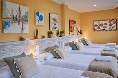 a living room with three beds with pillows at Peregrina Pensión 1 in O Pedrouzo