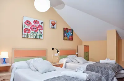 a room with two beds in a attic at Peregrina Pensión 1 in O Pedrouzo