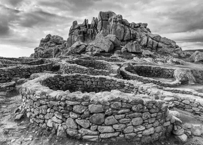 a stone wall in front of a rocky mountain at A Casa da Meixida in Padrón
