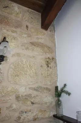 a stone wall with a vase on a table at A Casa da Meixida in Padrón