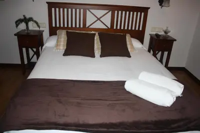 a large bed with white sheets and pillows at A Casa da Meixida in Padrón