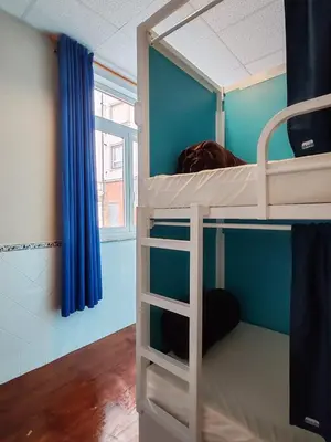 a bunk bed in a room with blue walls at Albergue A Ponte Ribadeo in Ribadeo
