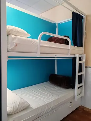 two bunk beds in a room with a blue wall at Albergue A Ponte Ribadeo in Ribadeo