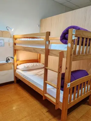 two wooden bunk beds in a room with at Albergue A Ponte Ribadeo in Ribadeo