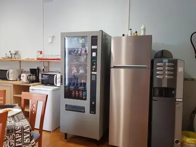 a refrigerator is next to a microwave and a kitchen at Albergue A Ponte Ribadeo in Ribadeo