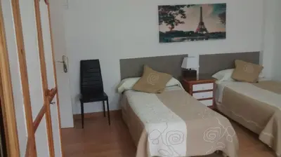 a bedroom with a bed and a chair and a desk at Pension Santa Rita in Santiago de Compostela