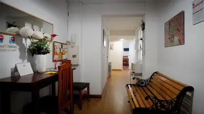 a room with a wooden bench and a table and a hallway at Pension Santa Rita in Santiago de Compostela