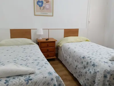 two beds sitting next to each other in a bedroom at Pension Santa Rita in Santiago de Compostela