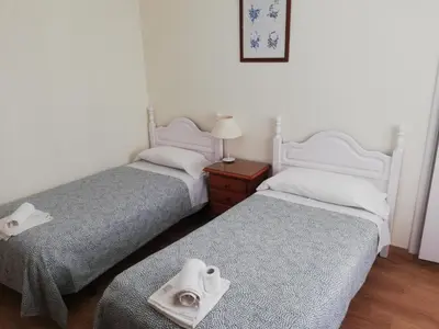 two beds in a room with towels on the beds at Pension Santa Rita in Santiago de Compostela