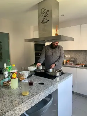 a man standing in a kitchen preparing food at La Rosa Azul Rooms-Grupo Rosa Azul in Ponferrada