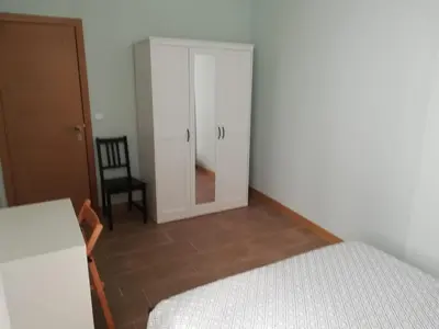 a bedroom with a bed and a chair and a mirror at La Encina Azul Rooms-Grupo Rosa Azul in Ponferrada