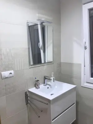 a white bathroom with a sink and a mirror at La Encina Azul Rooms-Grupo Rosa Azul in Ponferrada