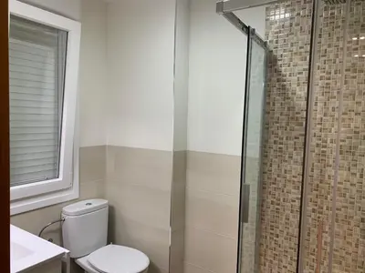a bathroom with a toilet and a glass shower at La Encina Azul Rooms-Grupo Rosa Azul in Ponferrada