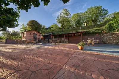 a patio with tables and chairs and a building at O Palleiro do Pe do Forno in Orellán