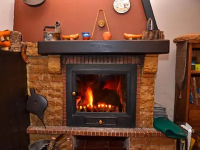 a fireplace with a fire inside of it at O Palleiro do Pe do Forno in Orellán