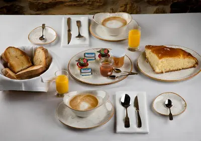 a table with a breakfast of cake and coffee and toast at O Palleiro do Pe do Forno in Orellán