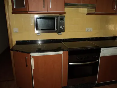 a kitchen with a microwave and a stove at Apartamentos Casa Rosendo in Cangas del Narcea