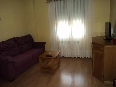 a living room with a purple couch and a window at Apartamentos Casa Rosendo in Cangas del Narcea