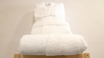 a stack of white towels sitting on a shelf at Apartamentos AUGA in Fene