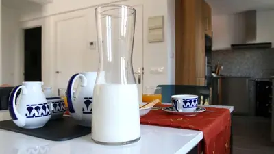 a glass vase filled with milk on a kitchen counter at Apartamentos AUGA in Fene
