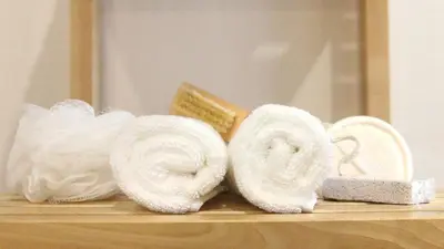 a pile of towels on a shelf in front of a mirror at Apartamentos AUGA in Fene