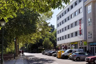 a street with cars parked on the side of a building at Hotel San Lázaro in Santiago de Compostela
